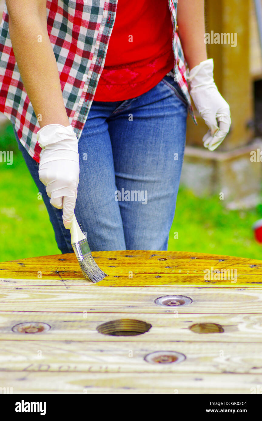 woman wearing gloves applying lacquer to a table Stock Photo Alamy