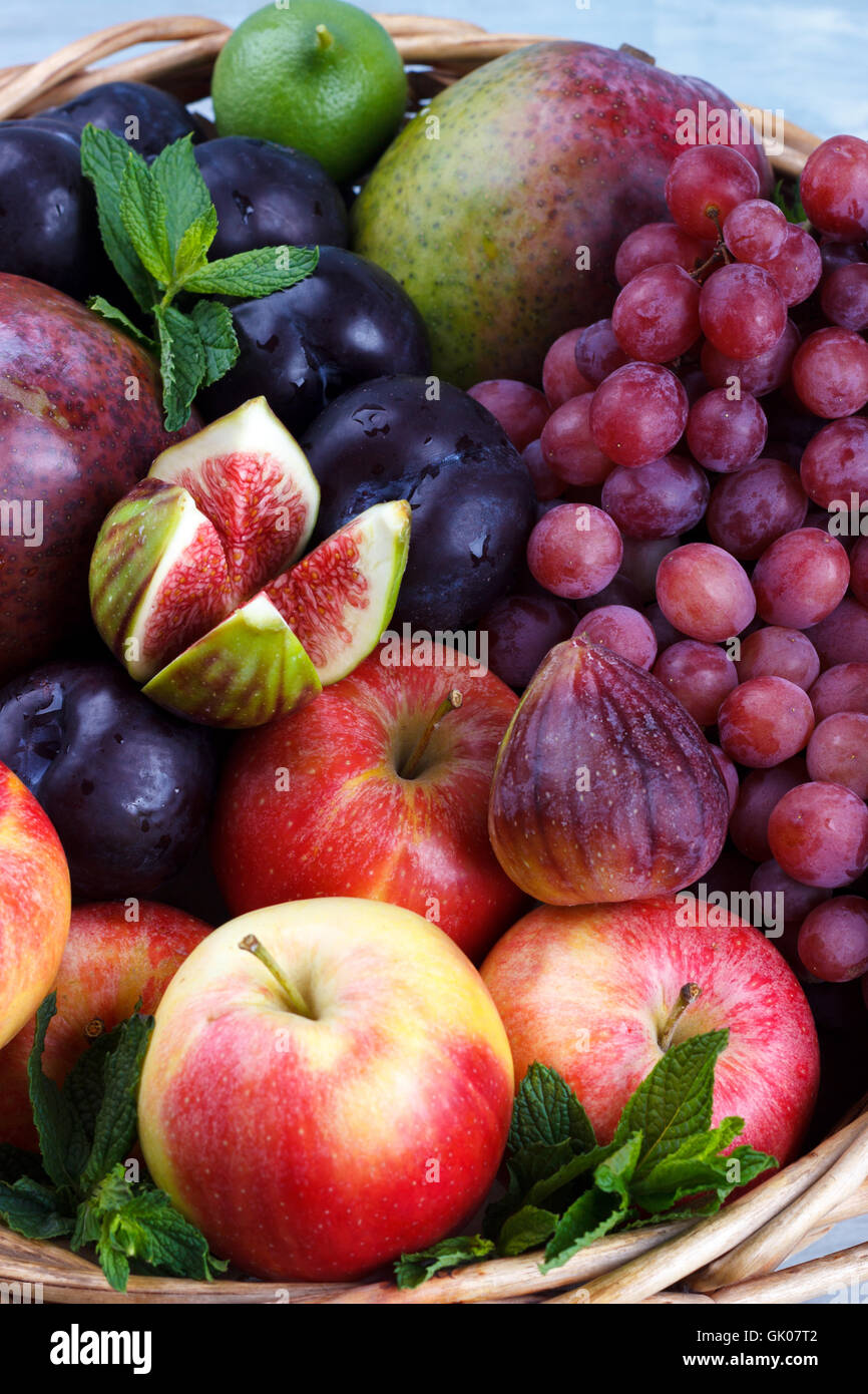 Basket of fresh organic fruits in the garden on rustic background Stock Photo