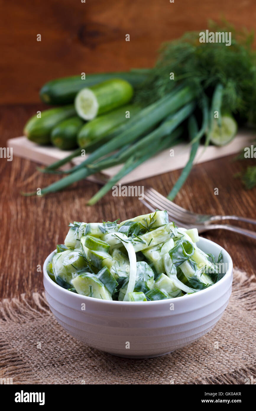 Fresh cucumber and dill salad with yogurt garlic dressing on wooden board Stock Photo