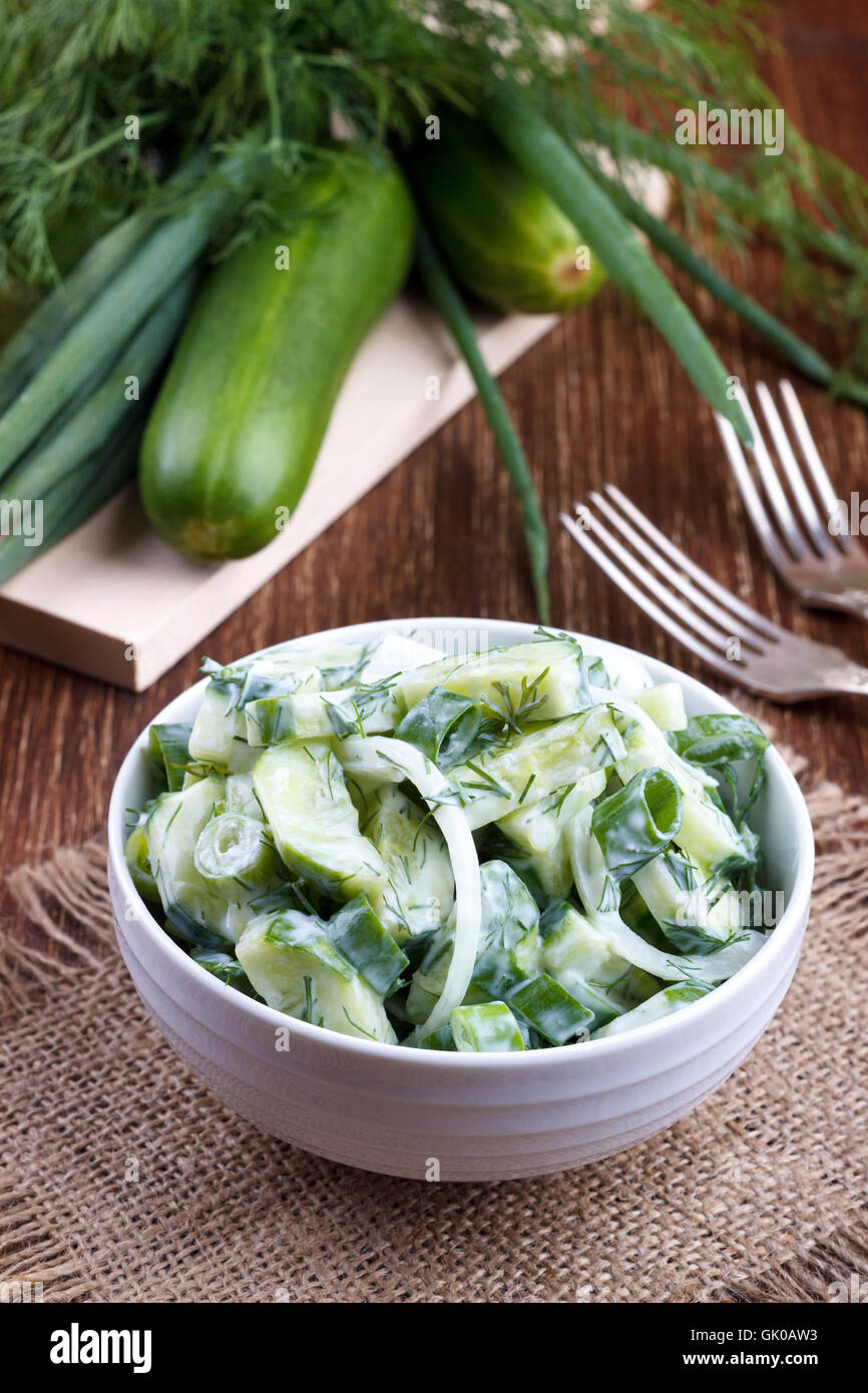 Fresh cucumber and dill salad with yogurt garlic dressing on wooden board Stock Photo