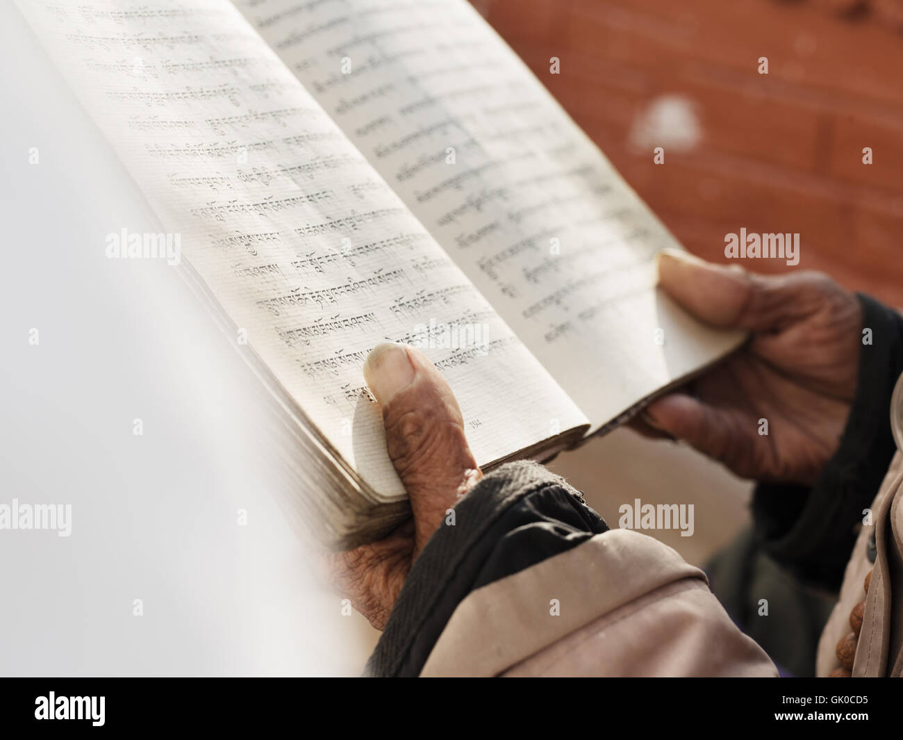 A man holds a prayer book in the Boudhanath Pagoda in Kathmandu, Nepal. Stock Photo