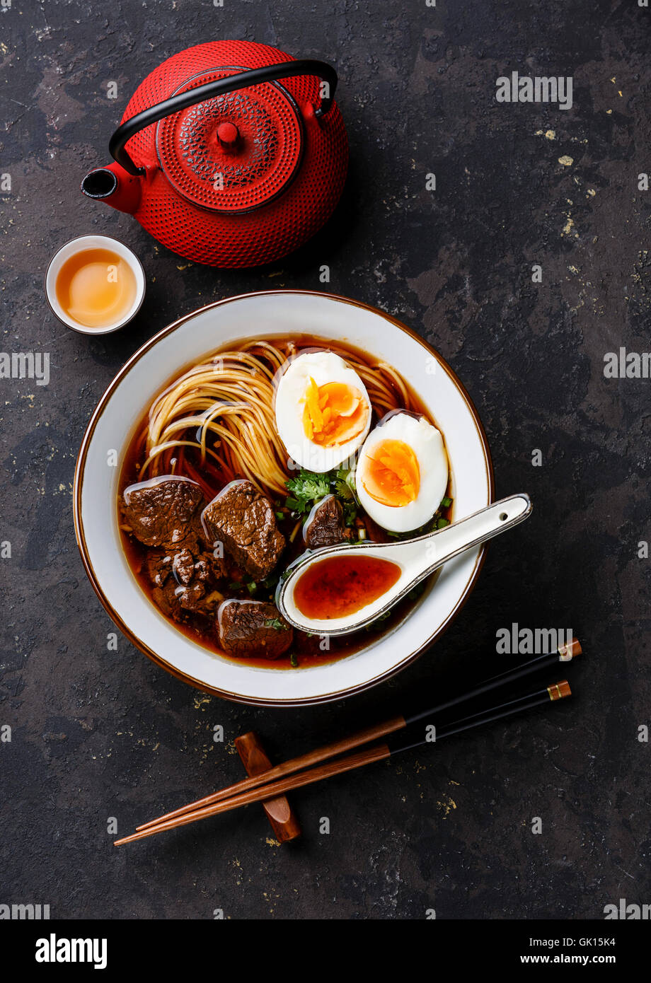 Asian noodles in broth with slow cooked Beef and Egg on dark background