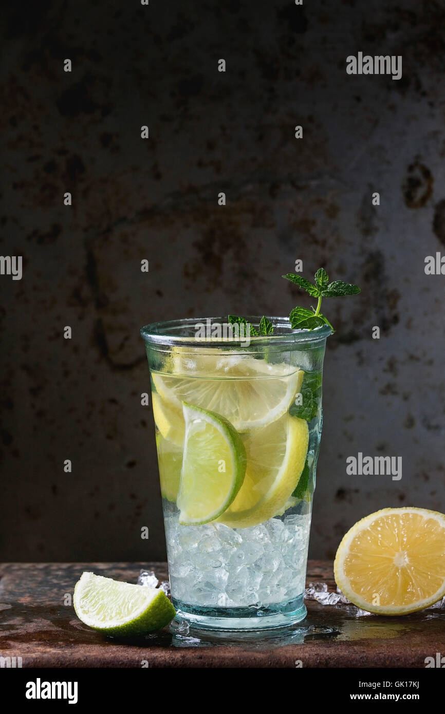 Homemade lemon and lime lemonade, served in glass  with ice and fresh mint, oveer dark iron rusty background. With space for tex Stock Photo