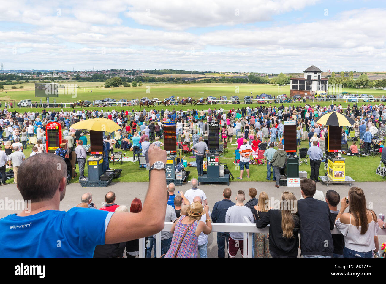 Cheering on a winner at the races. Punching the air can help your horse over the finish line. Stock Photo