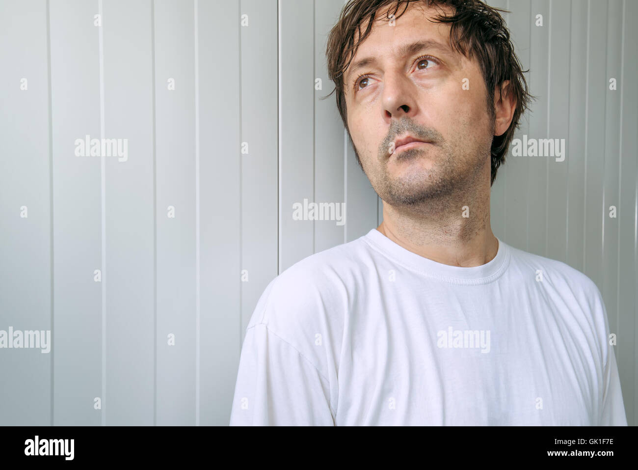 Concentrated pensive man looking up and thinking positive thoughts Stock Photo