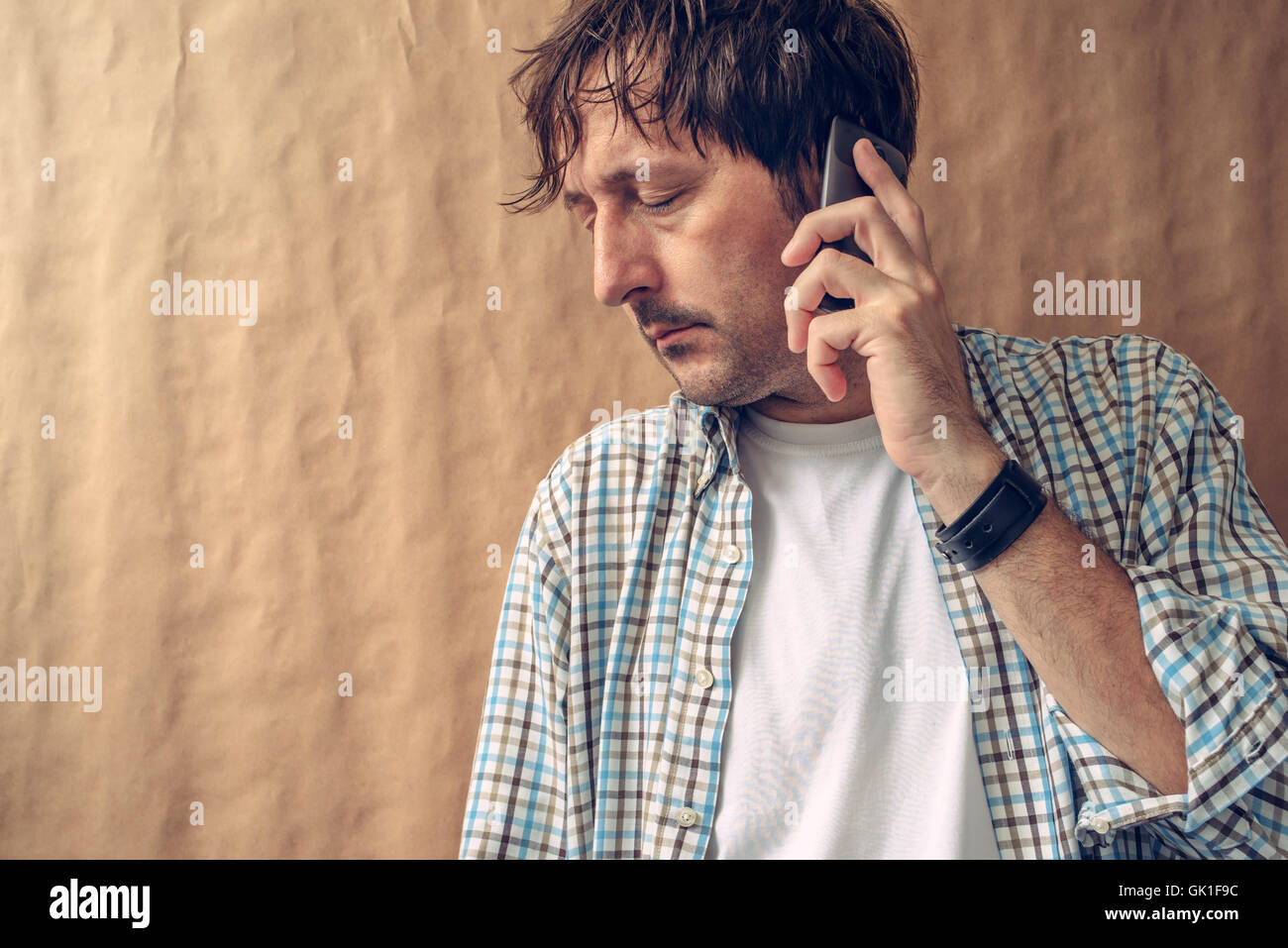 Man hearing bad news on the phone, adult caucasian male using mobile telephone device Stock Photo