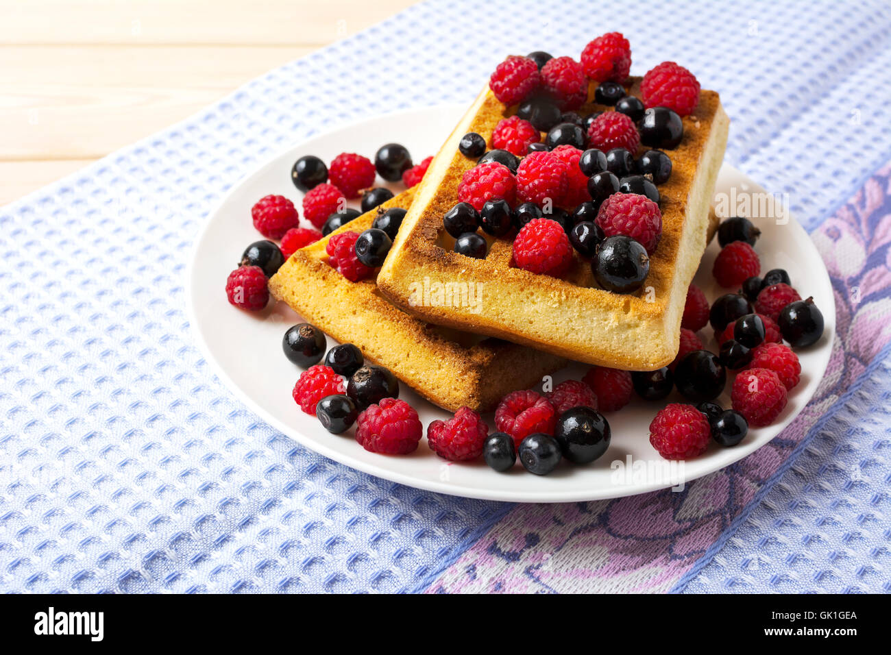 Soft Belgian waffles with blueberry, raspberry and blackcurrant. Breakfast waffles with fresh berries. Stock Photo