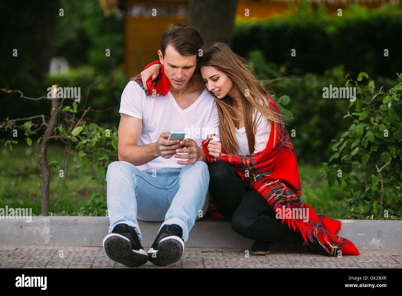 Beautiful young couple relaxing in the park Stock Photo - Alamy