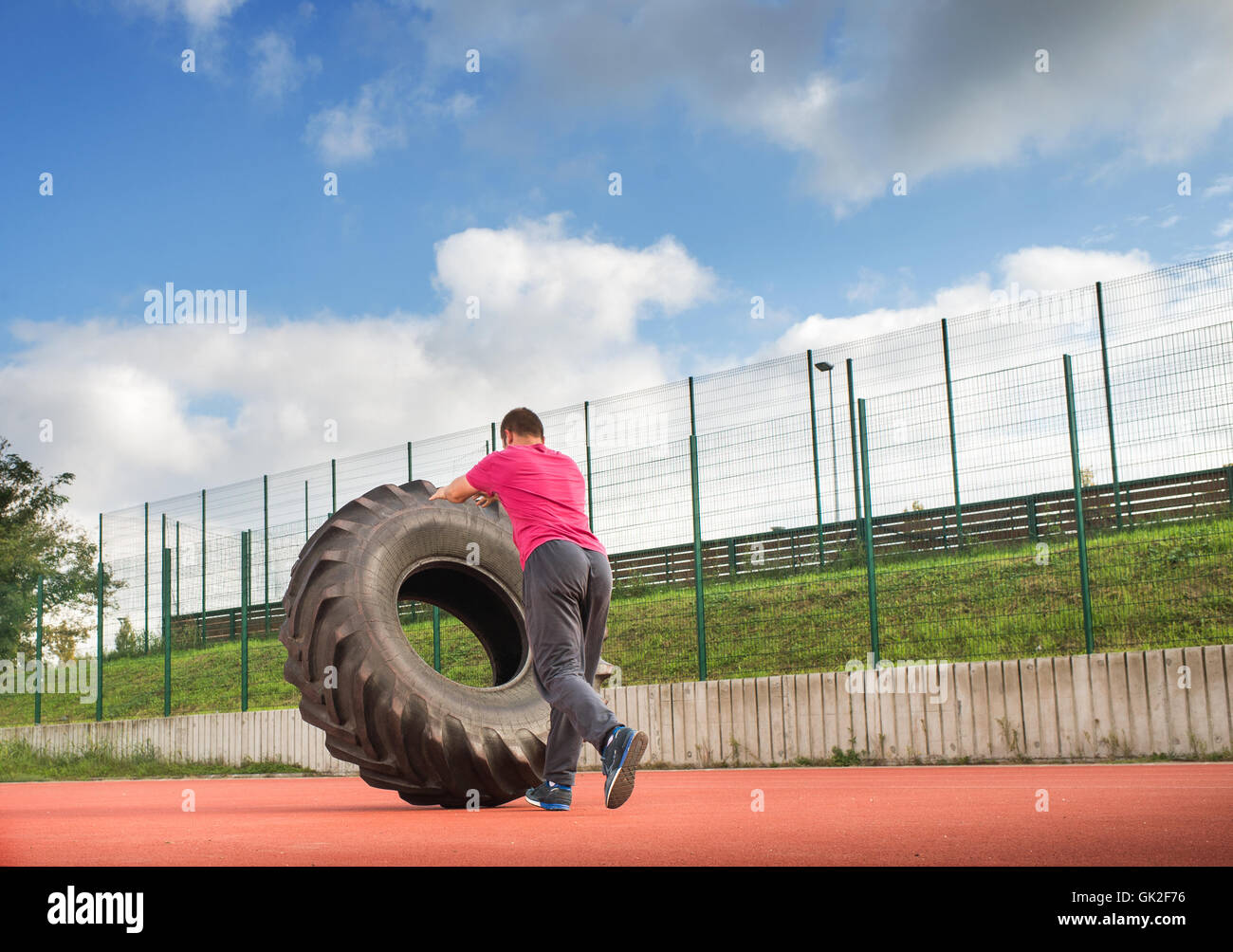 Young man does strongman exercise Stock Photo