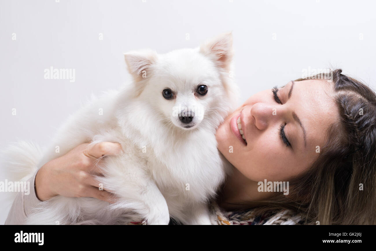 Happy girl with her little dog in studio Stock Photo - Alamy