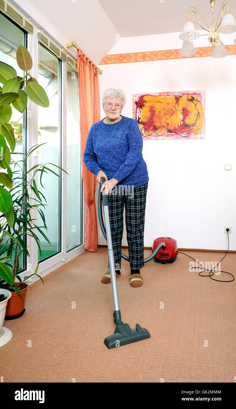 senior with vacuum cleaner Stock Photo Alamy