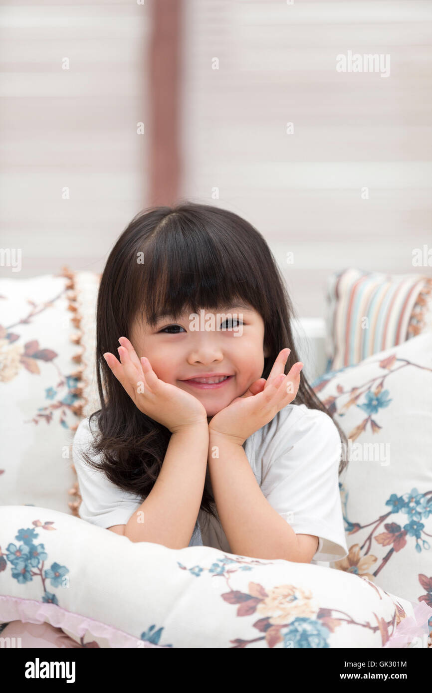 Happy little girl sitting on the couch Stock Photo - Alamy