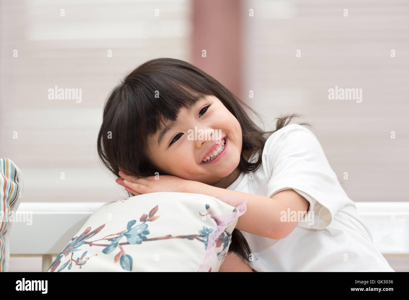 Happy little girl sitting on the couch Stock Photo - Alamy