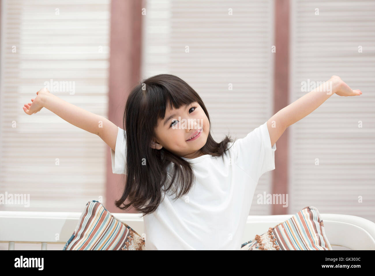 Happy little girl sitting on the couch Stock Photo - Alamy