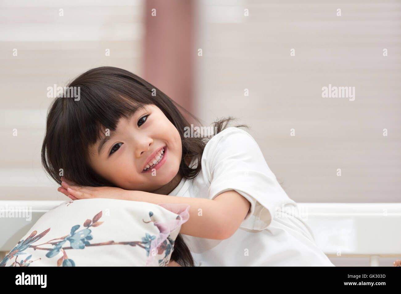 Happy little girl sitting on the couch Stock Photo - Alamy
