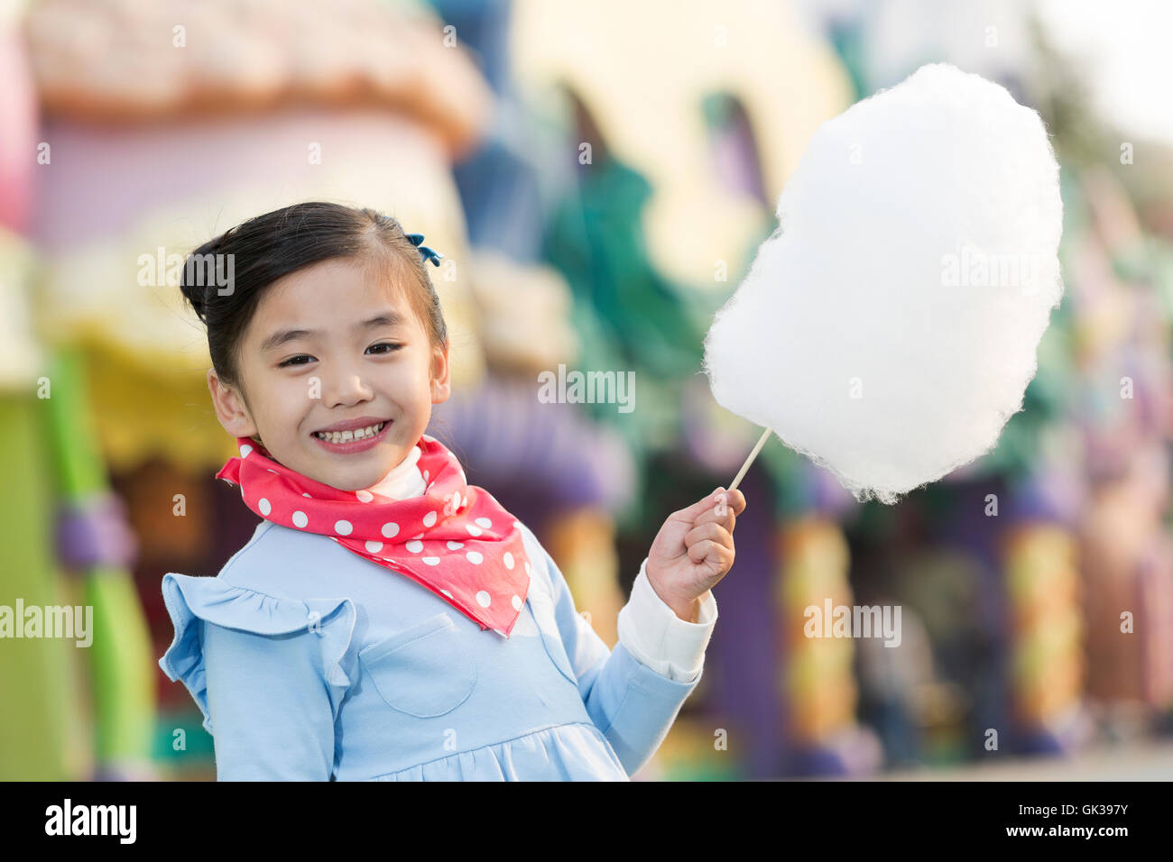 Little girl eating cotton candy at the amusement park Stock Photo Alamy
