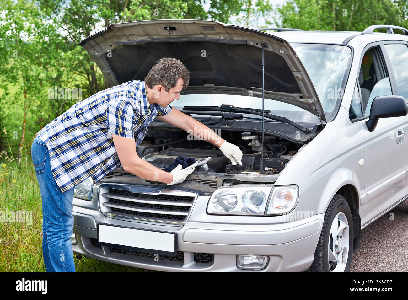 Man trying to repair broken car yourself Stock Photo - Alamy
