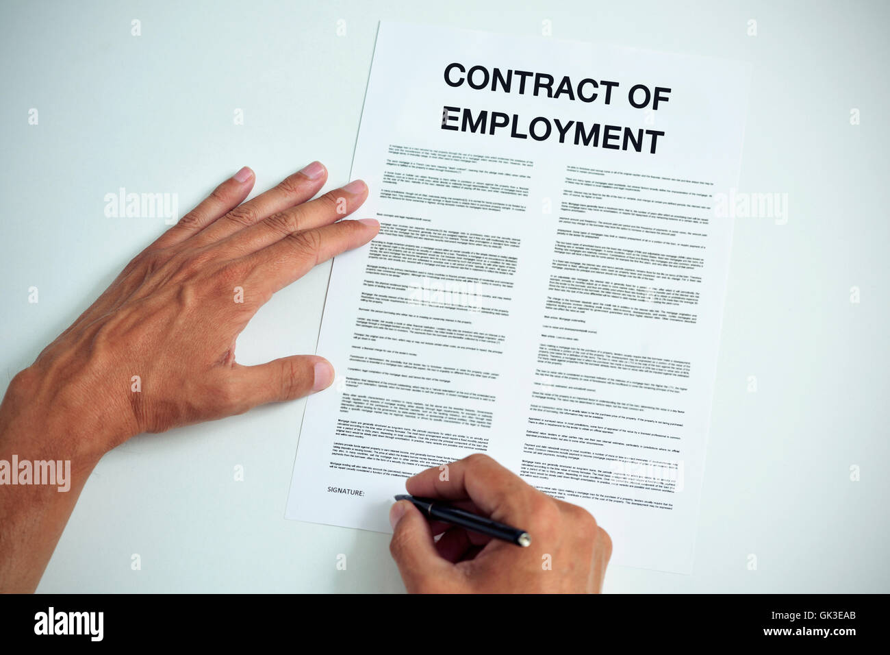 Candidate Sign Contract closeup of a young caucasian man about to sign a contract of employment ...