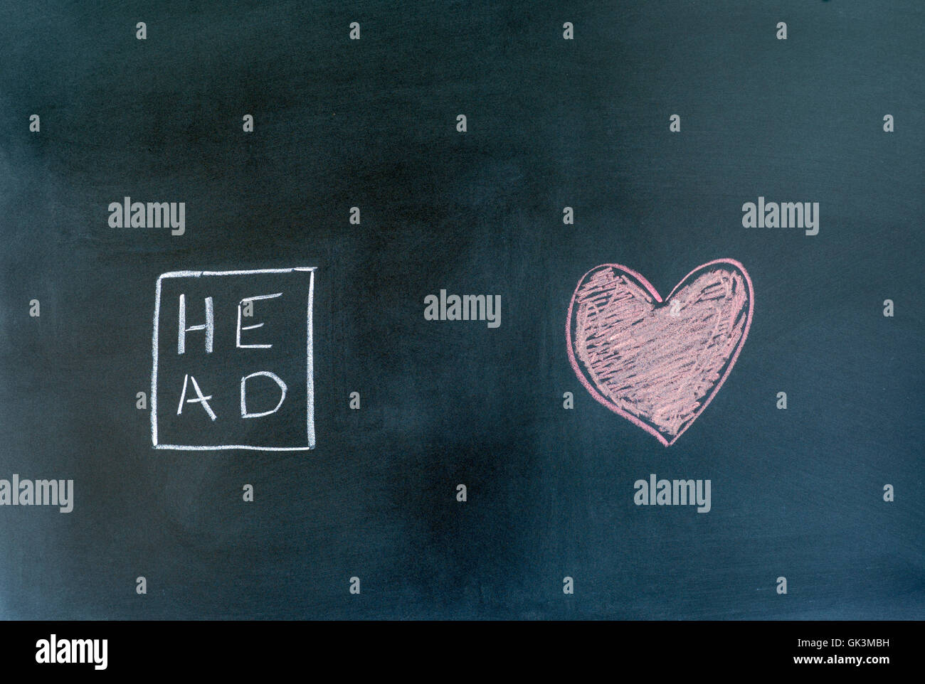 head and heart symbols drawn on a chalkboard. Stock Photo
