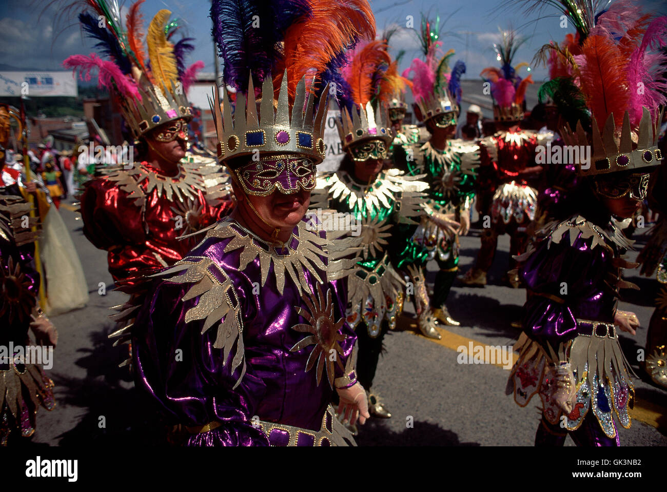 ca. 1980-1995 --- People in costume parade through the streets during the Festival of the Devil. | Location: Rio Sucio, Caldas, Stock Photo