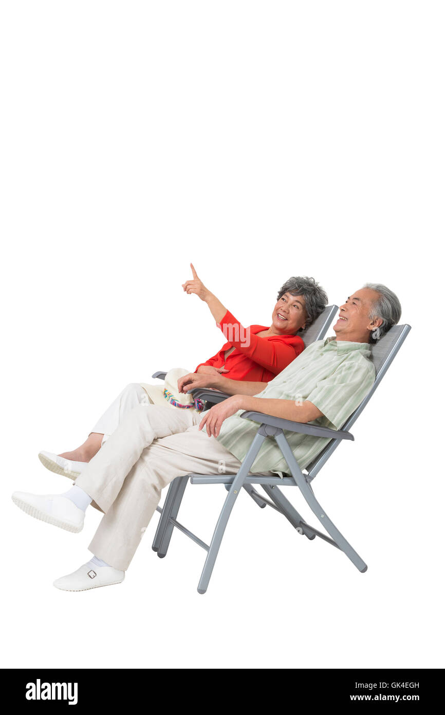 Happy elderly couple sitting on a beach chair Stock Photo - Alamy