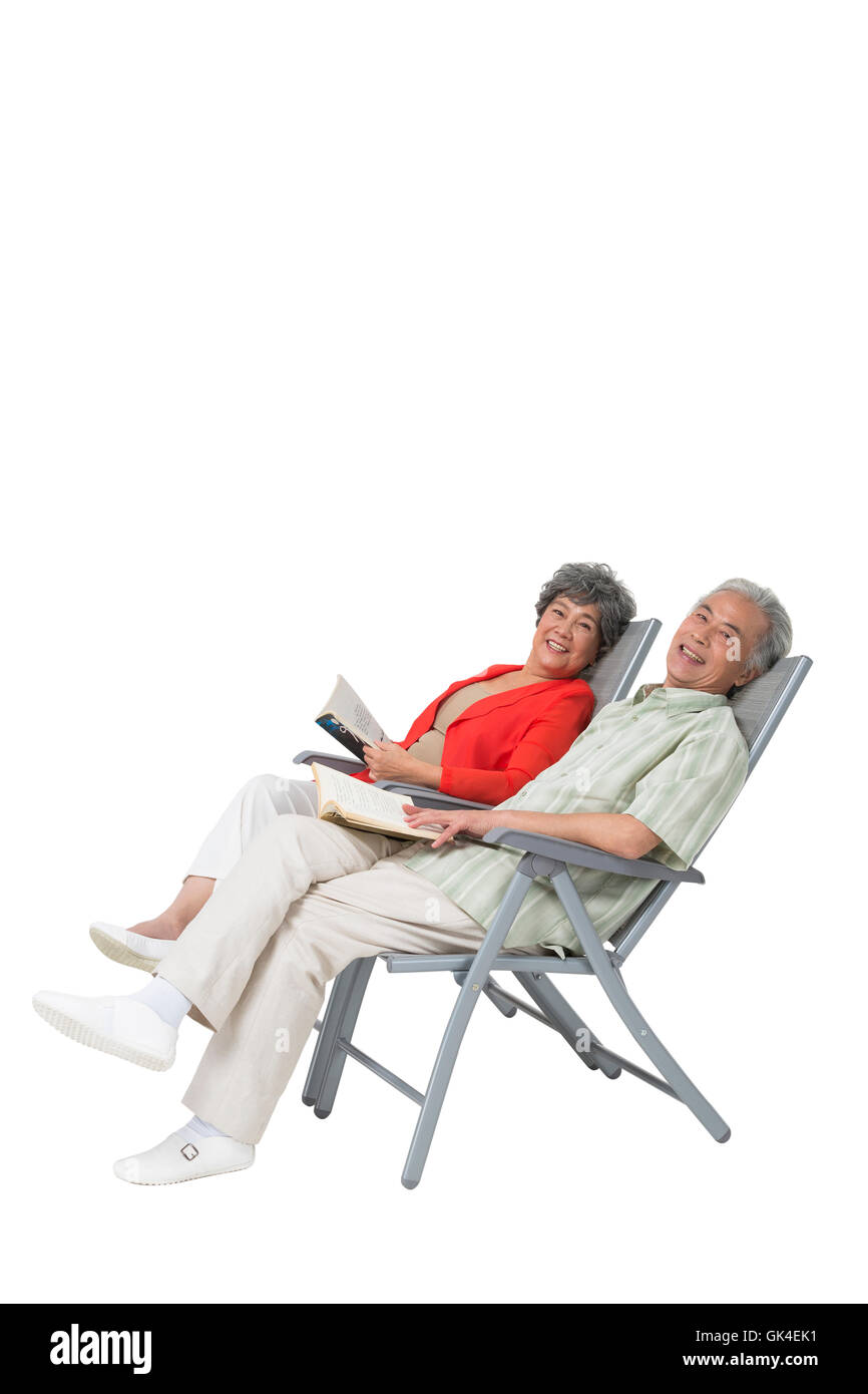 Happy elderly couple sitting on a beach chair Stock Photo - Alamy