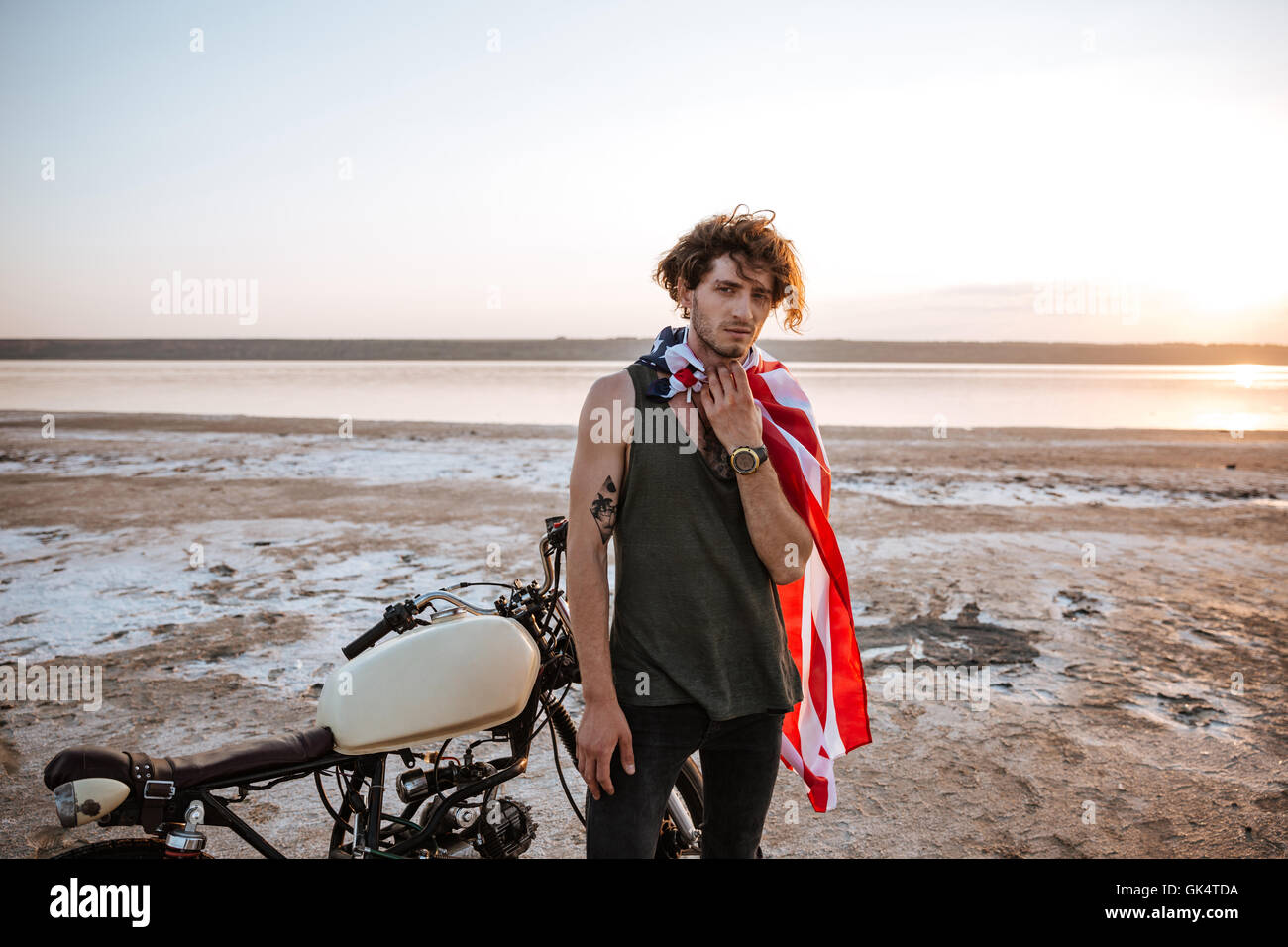 Serious brutal man wearing american flag cape and golden helmet