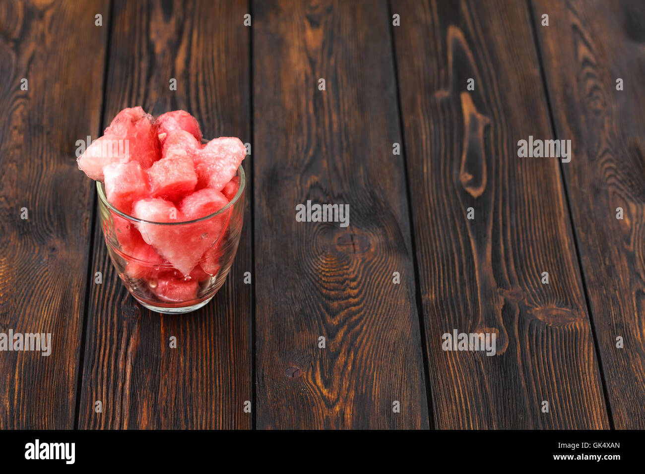Heartshape slices of watermelon in glass on wooden background Stock Photo