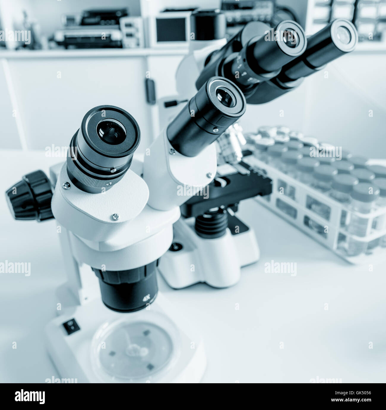 Science microscope on lab bench. Microbiology laboratory. Blue toned image of binocular microscope Stock Photo