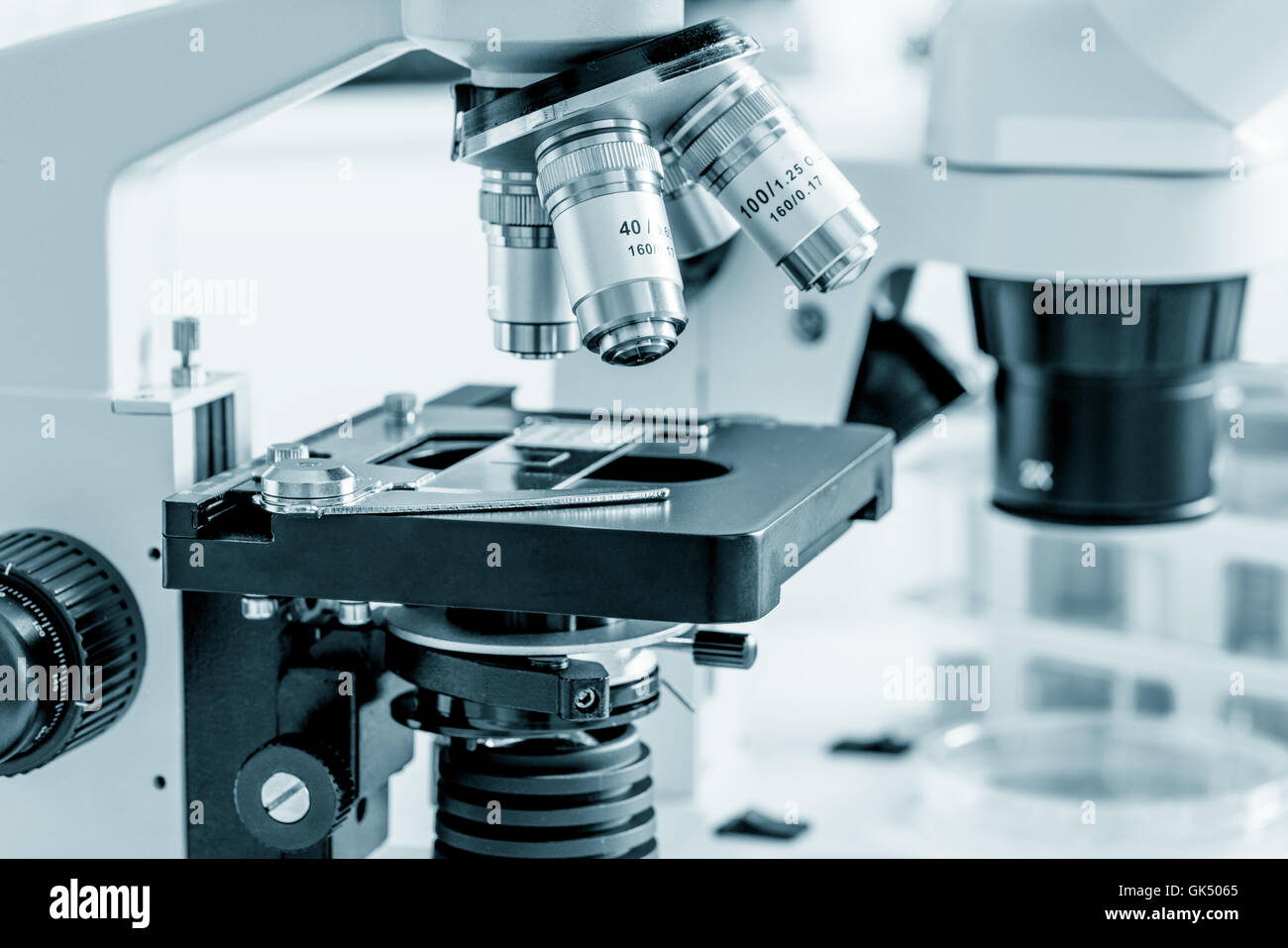 Science microscope on lab bench. Microbiology laboratory. Blue toned