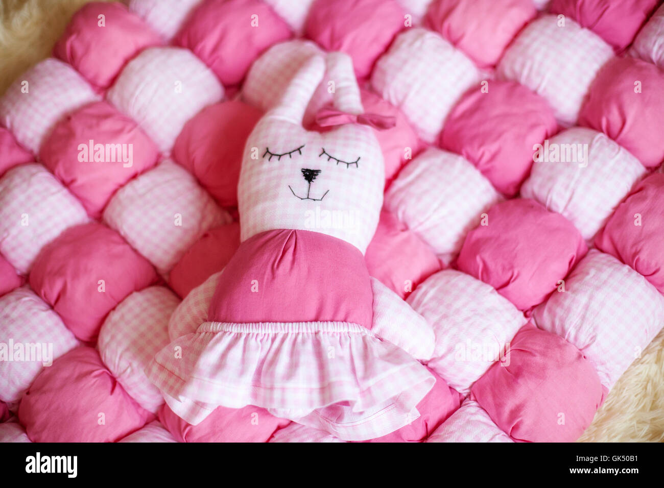 Cute little doll on pink blanket. Pregnancy concept Stock Photo