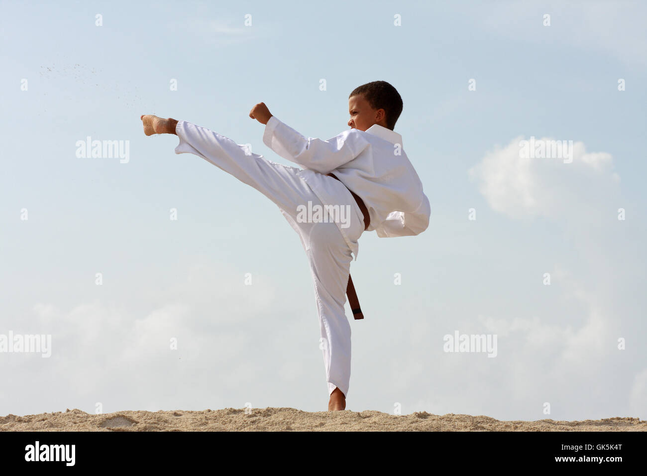 11-years boy doing Tae Kwon Do work-out on the Caribbean island beach. Stock Photo