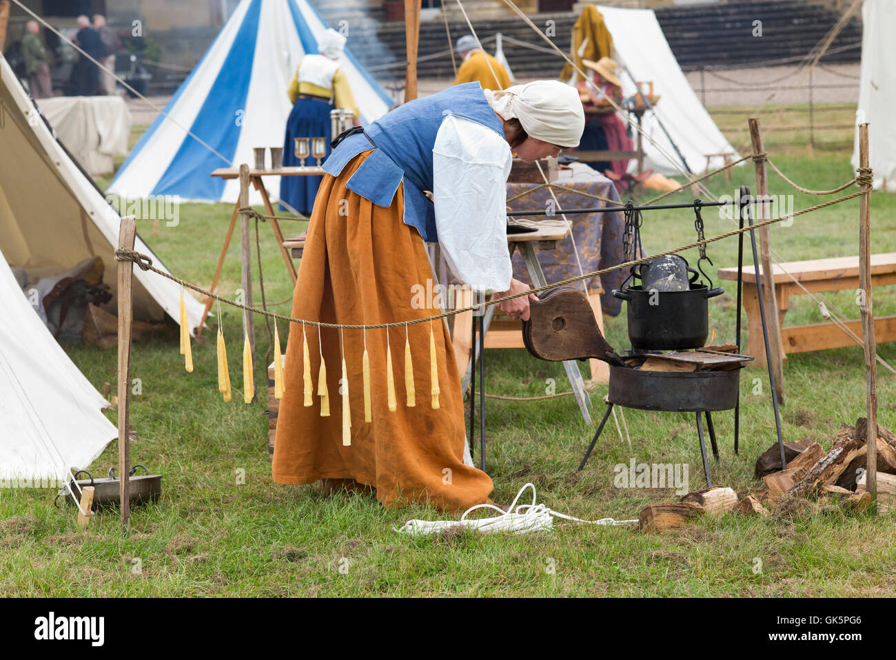 Woman making candles in an english civil war camp at a living history