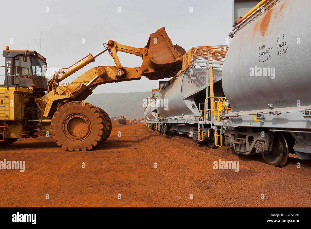 Rail head operations at mine with new wagons on train being loaded with hematite iron ore stock before travelling to port for sale to overseas markets Stock Photo