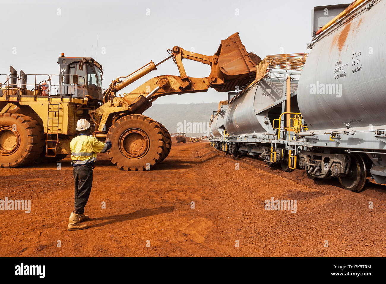 Rail head operations at mine with new wagons on train being loaded with hematite iron ore stock before travelling to port for sale to overseas markets Stock Photo