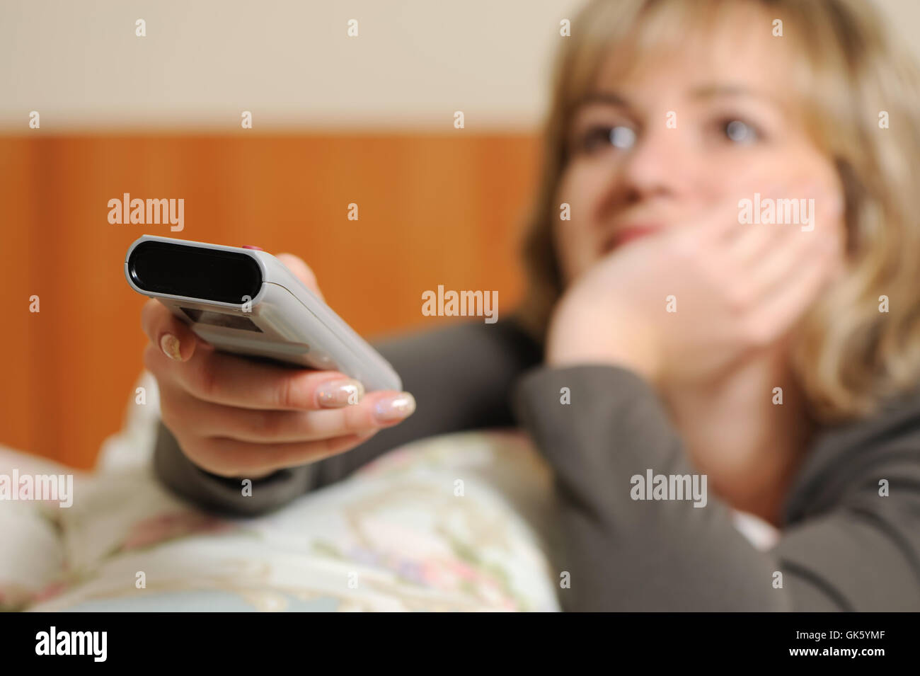 The woman with a television control panel. Selective focus Stock Photo ...