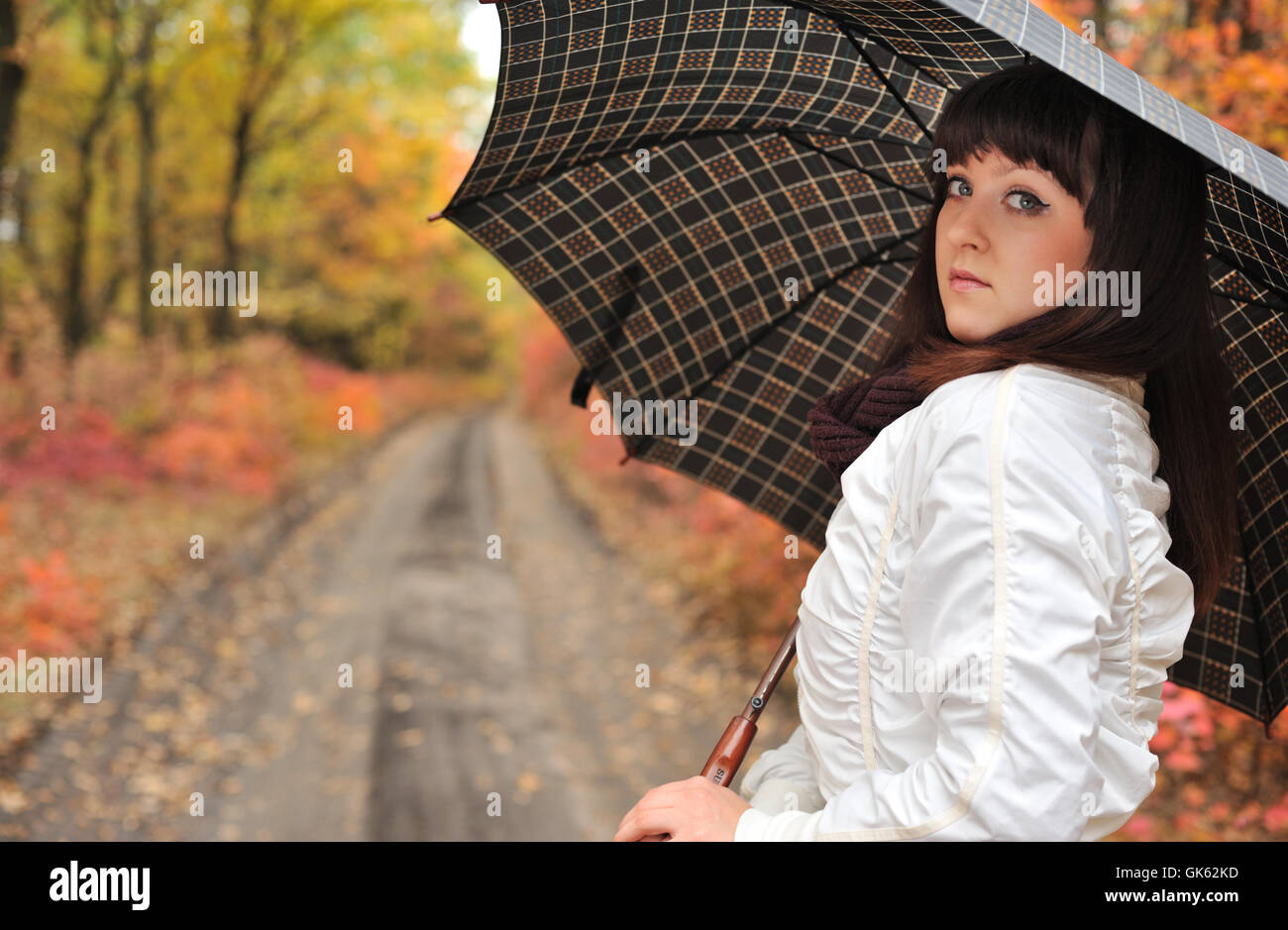 The girl in an autumn wood with a umbrella Stock Photo - Alamy