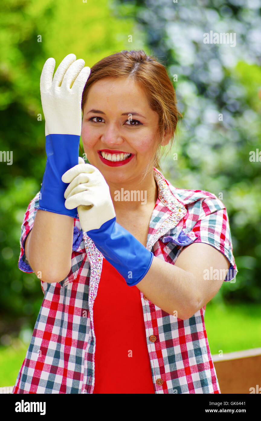 smilling women with colofull clothes putting on work gloves Stock Photo