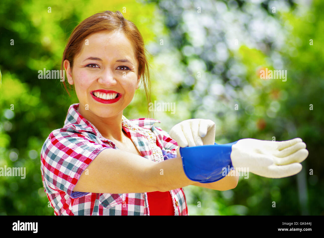 women dressed with colorfull clothes putting on work gloves Stock Photo