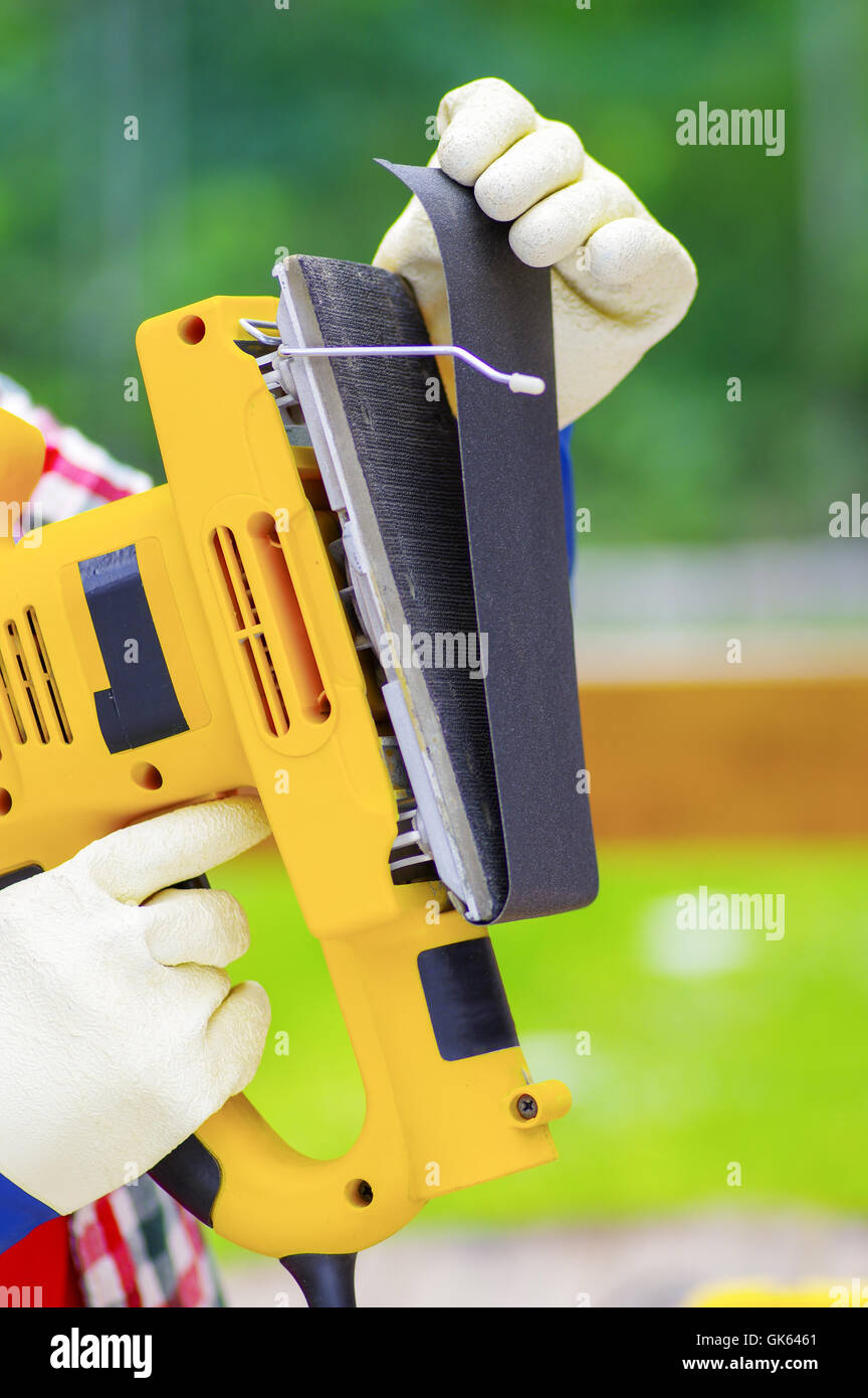 hadn removing the sandpaper from the electric sander Stock Photo Alamy
