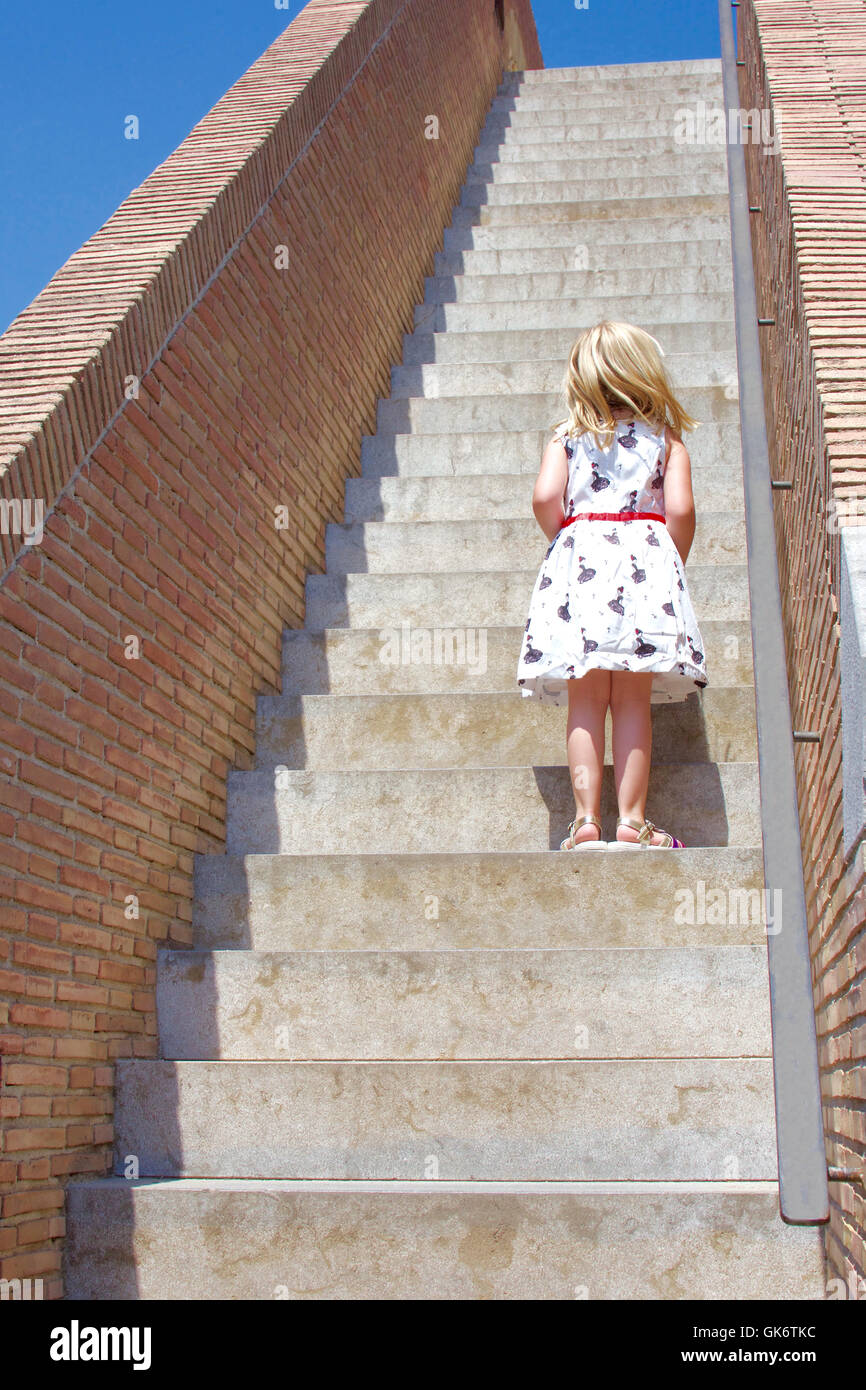 young girl climbing up large stairs Stock Photo Alamy
