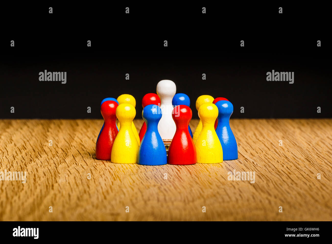 Concept: leader, leadership and adoration with a circle of pawn figures. With white pawn in center and colorful pawn figures aro Stock Photo