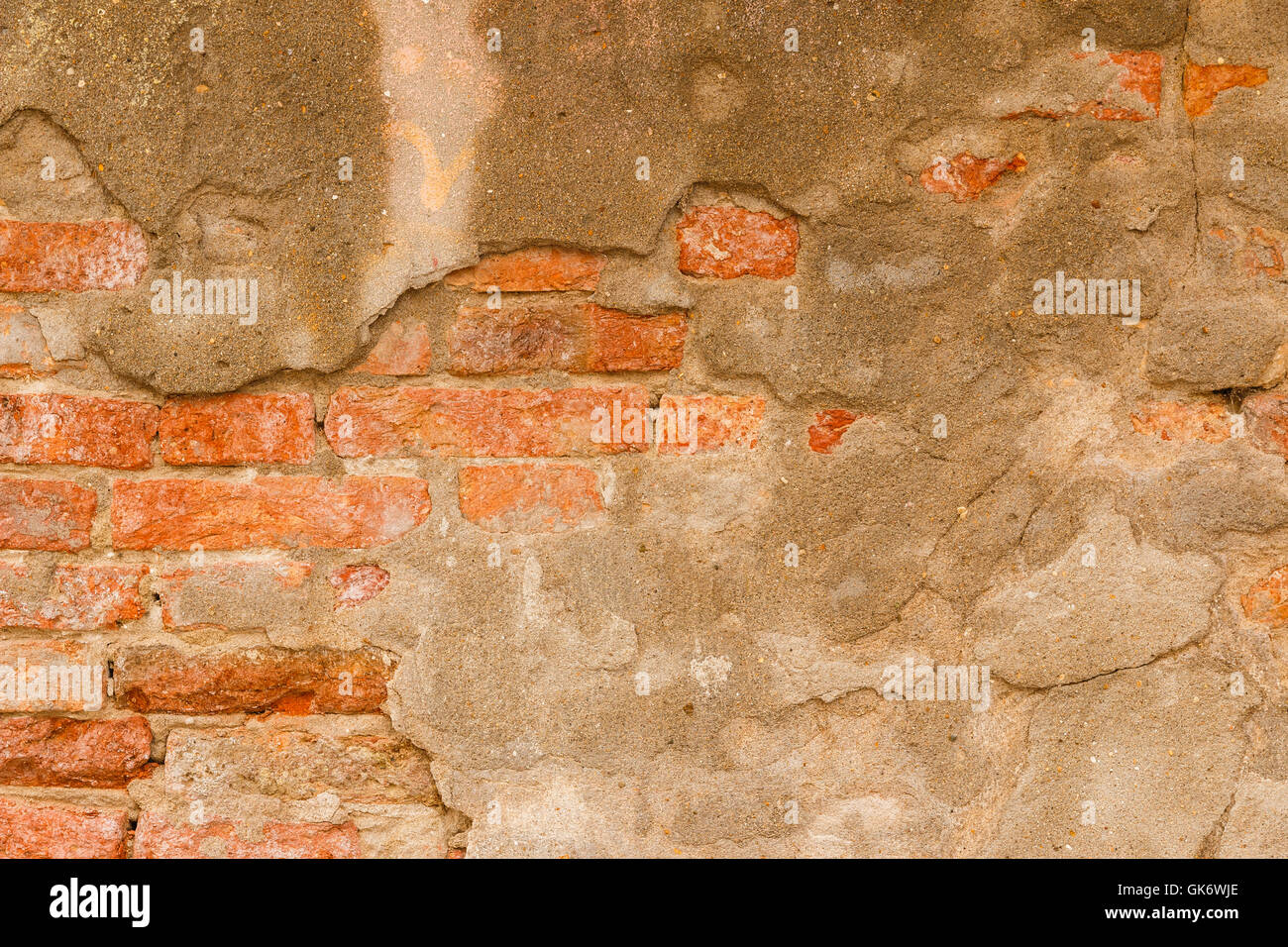 Old orange brick wall with rough cement Stock Photo