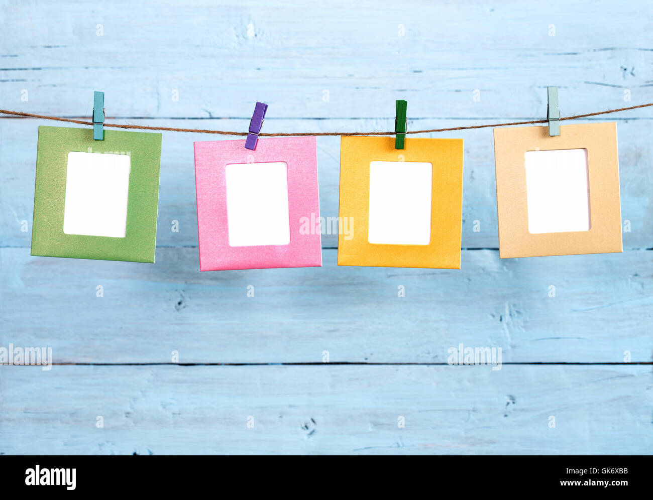 Four frames hanging on rope on blue background Stock Photo Alamy
