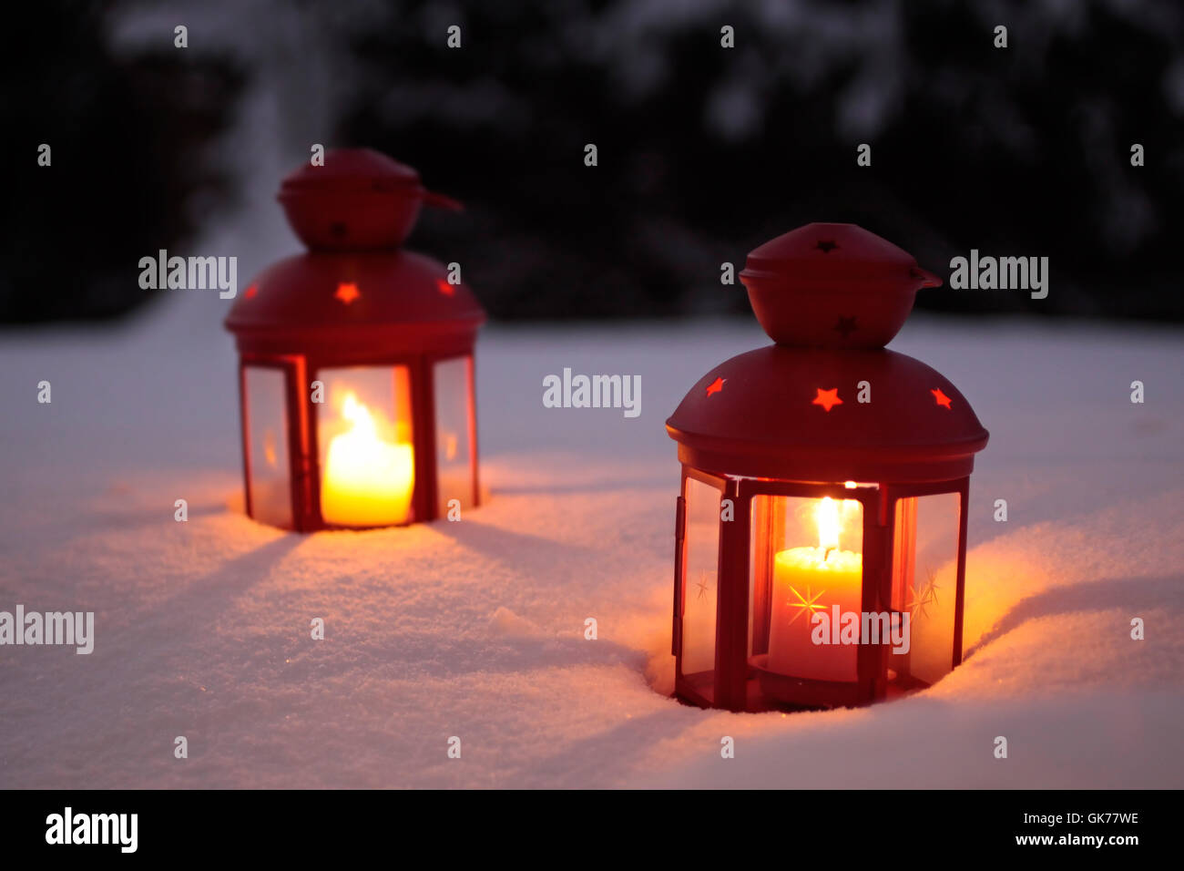 two burning lanterns in the snow Stock Photo