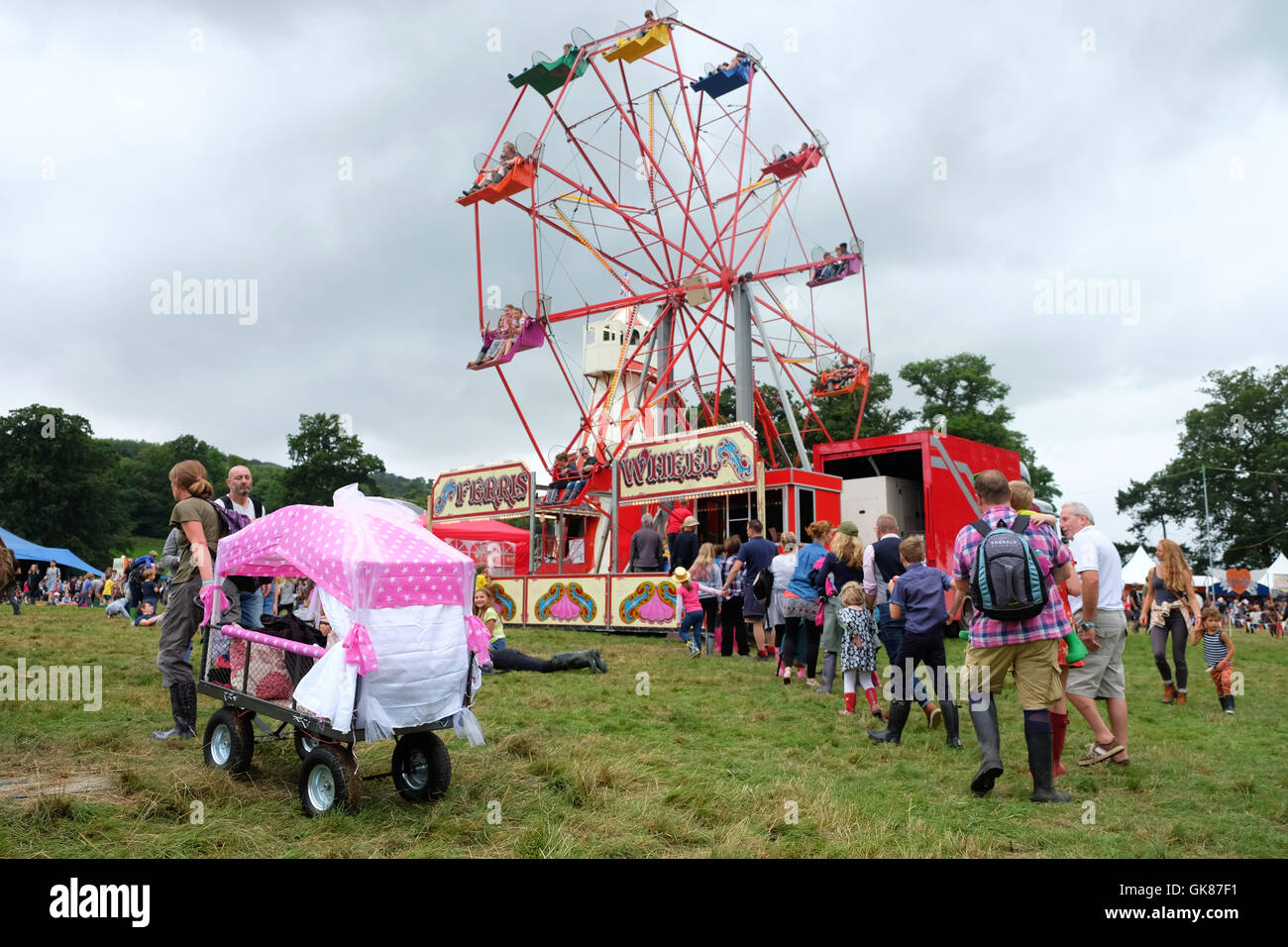 Green Man Festival, Wales, UK. 19th Aug, 2016.    Children and families queue for the ferris wheel as rain clouds move in - Over 25,000 music fans are due to attend over the weekend. Stock Photo