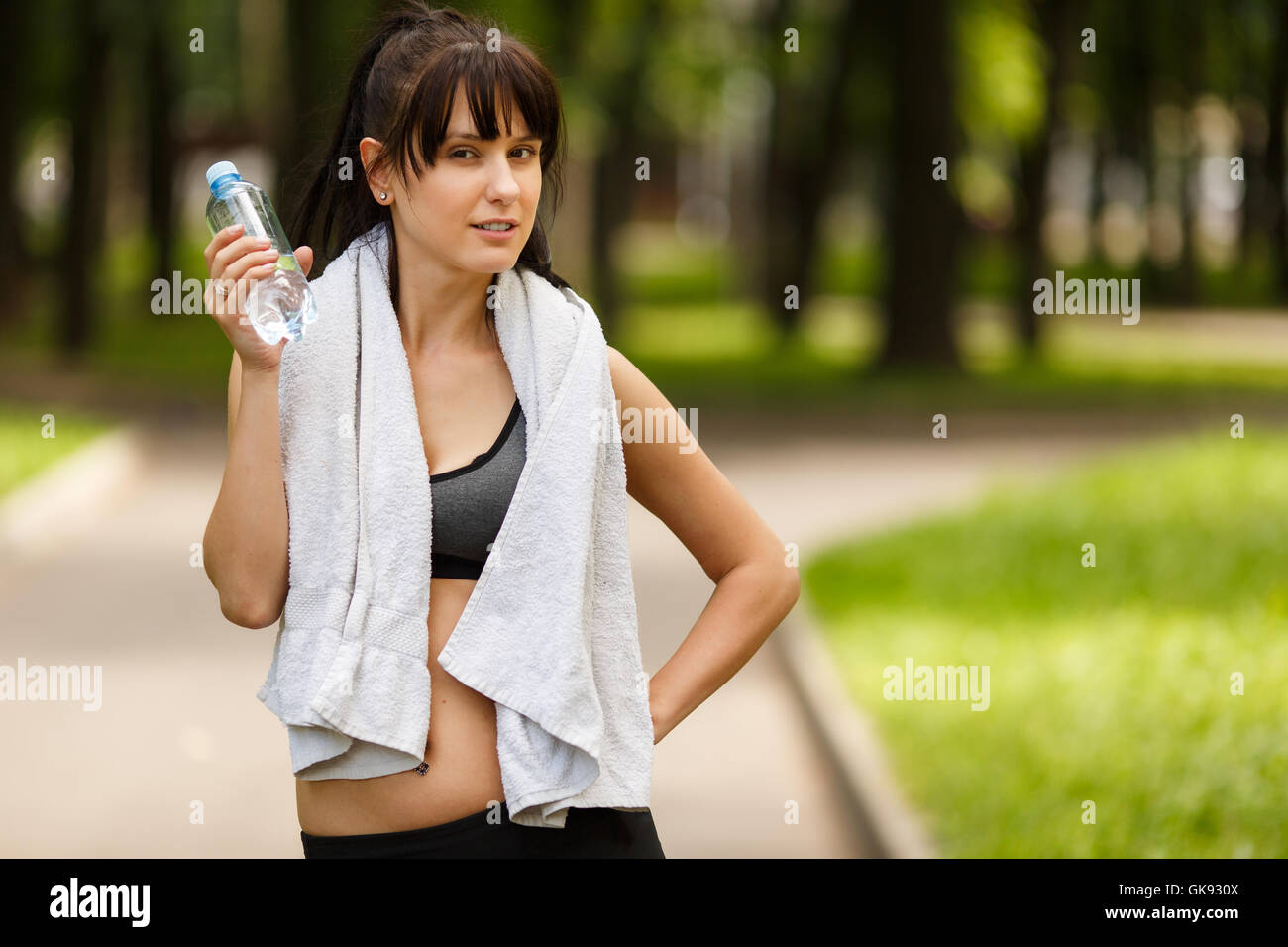 Young brunette sportswoman with towel and bottle of water Stock Photo ...