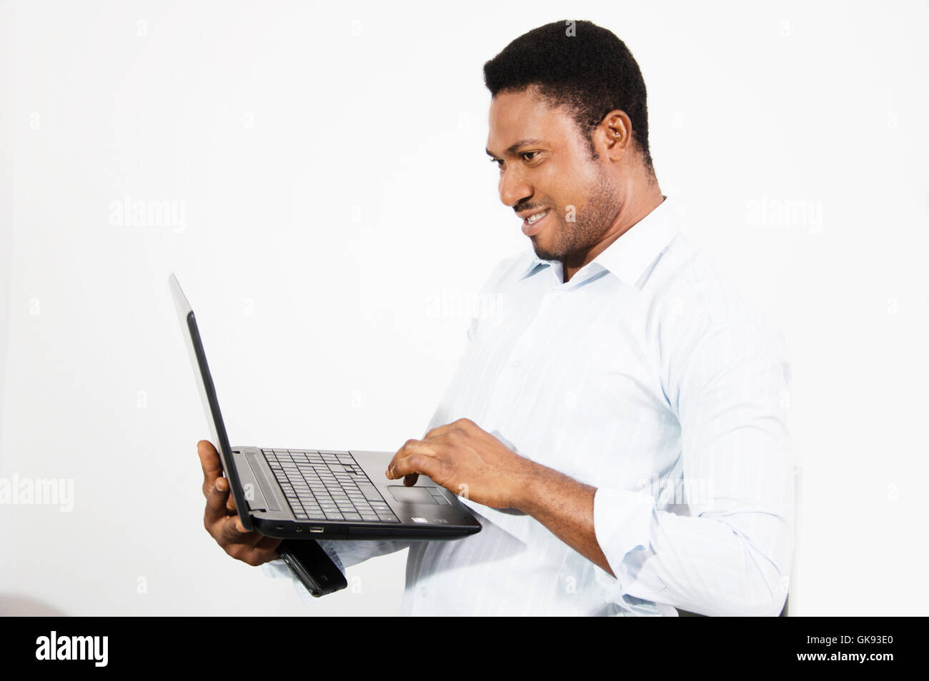 young man feels more confortable working standing with his laptop in hand. Stock Photo
