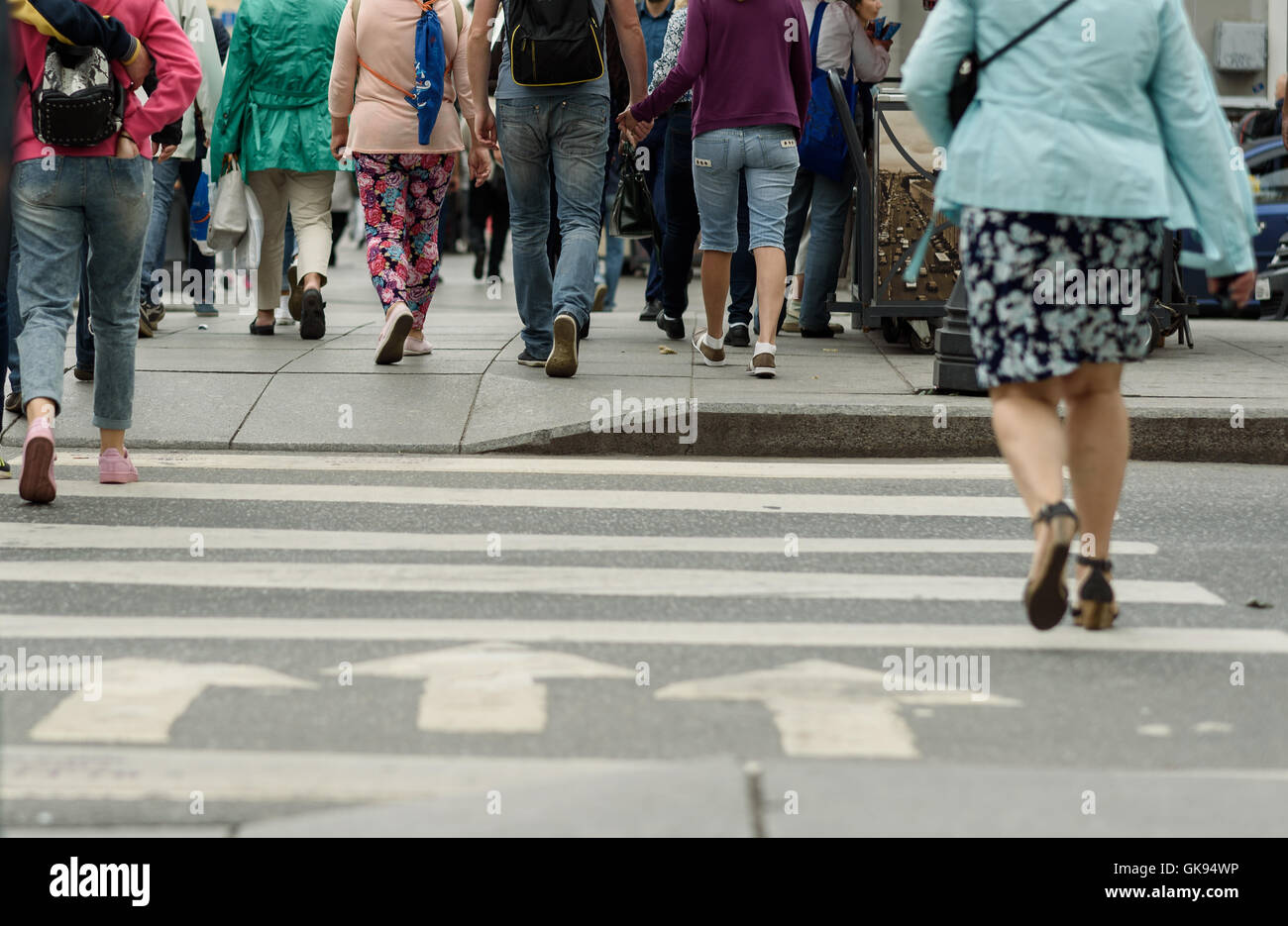 legs of people on a pedestrian crossing on a cloudy day Stock Photo