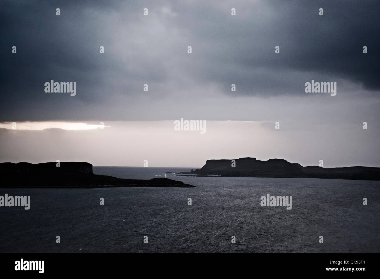 Dusk on the west of the island of Skye looking to Ardtreck Point lighthouse and island of Oronsay. Stock Photo
